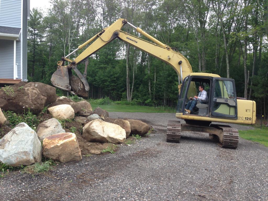 rocks are put in place for stone wall Bellingham MA